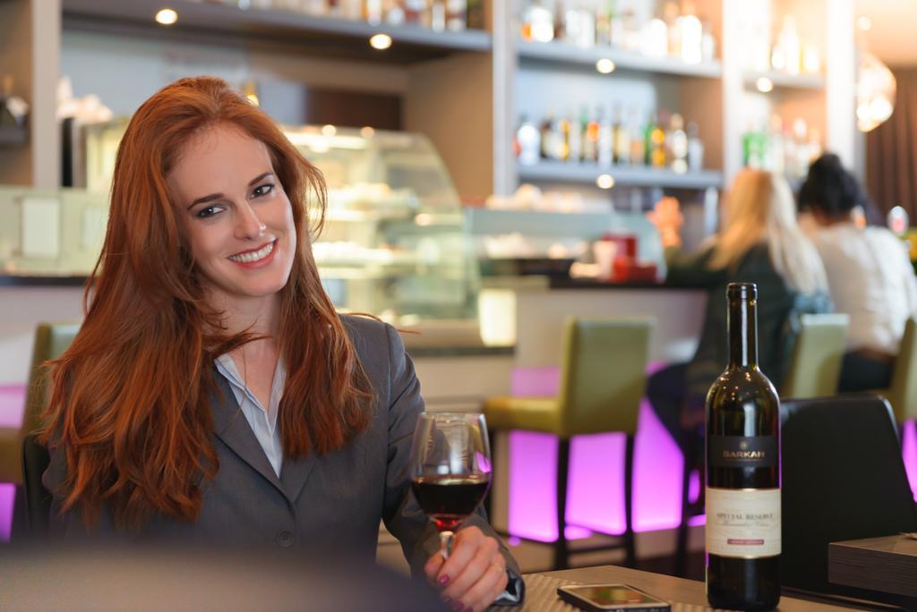 Leonardo City Tower Hotel Tel Aviv Giv'atayim Exteriér fotografie A woman drinking wine